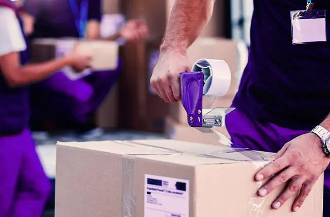 Trabajador sellando una caja con cinta